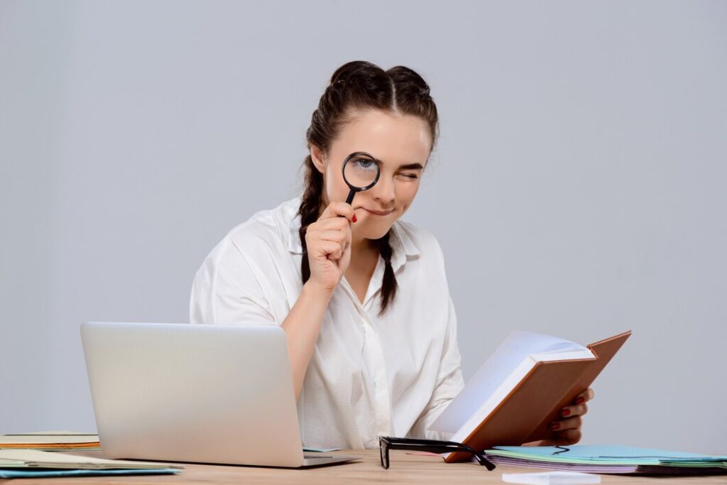 young beautiful businesswoman sitting workplace holding book magnifier 176420 2878